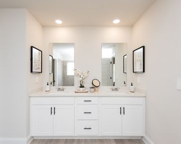 The primary bathroom features dual-vanity sinks and plenty of counter space for convenience.