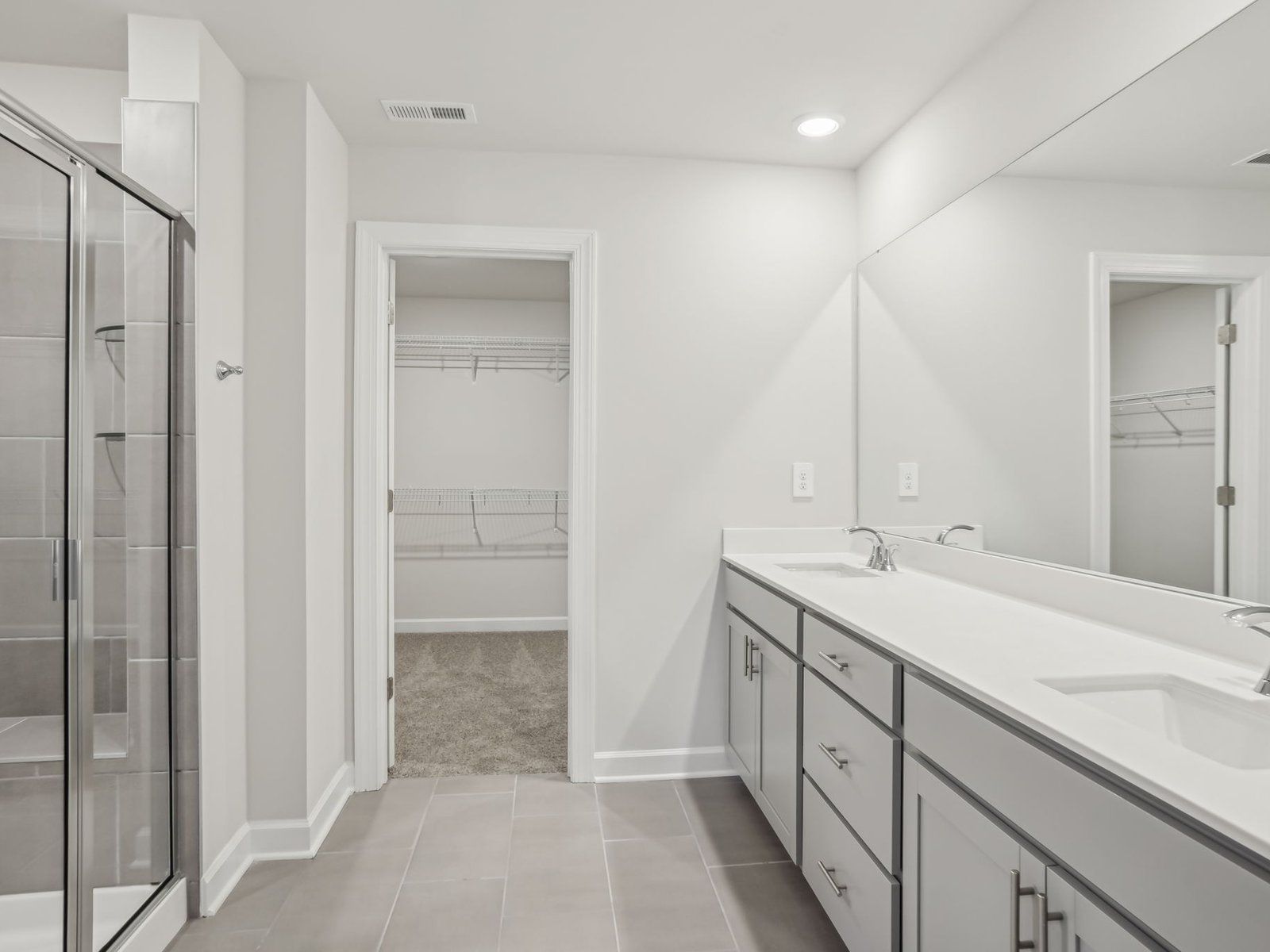 The primary bathroom boasts dual-sinks and a modern walk-in shower.