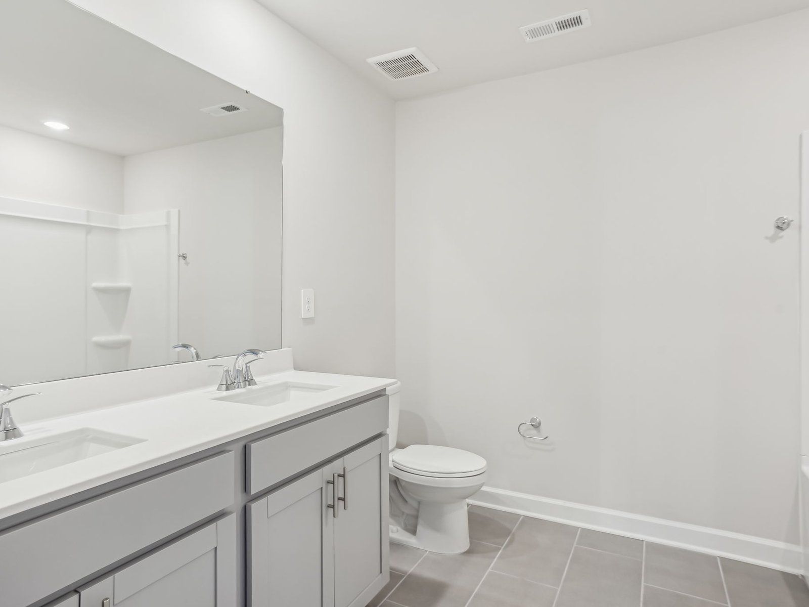 This secondary bathroom showcases an oversized tub and dual-sinks.