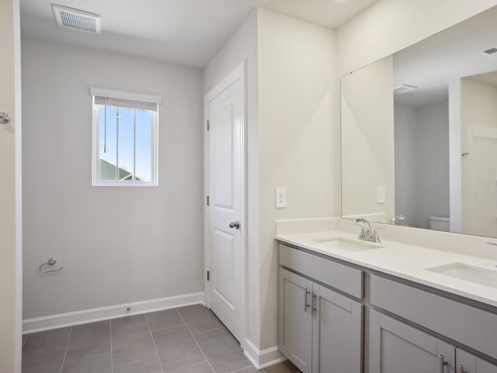 This secondary bathroom boasts an oversized shower tub and plenty of storage space.