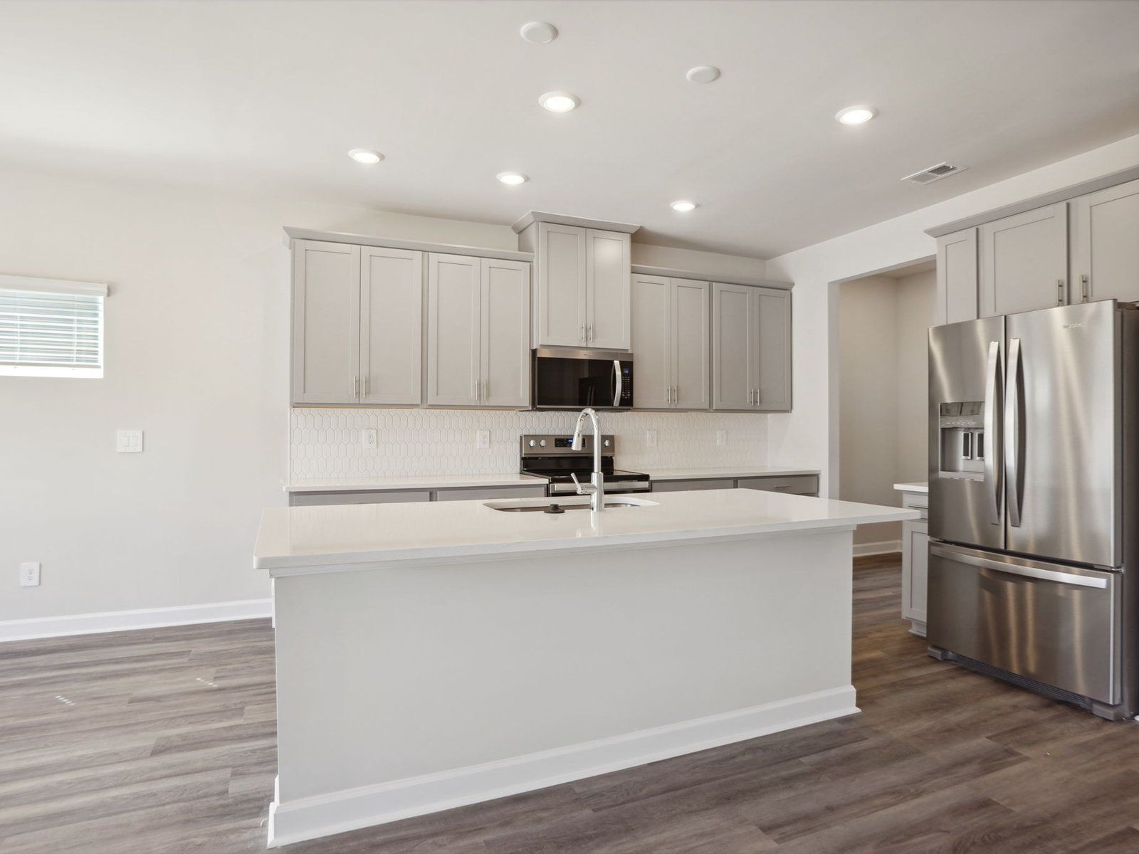 The kitchen boasts an oversized kitchen island and large storage cabinets for your essentials.