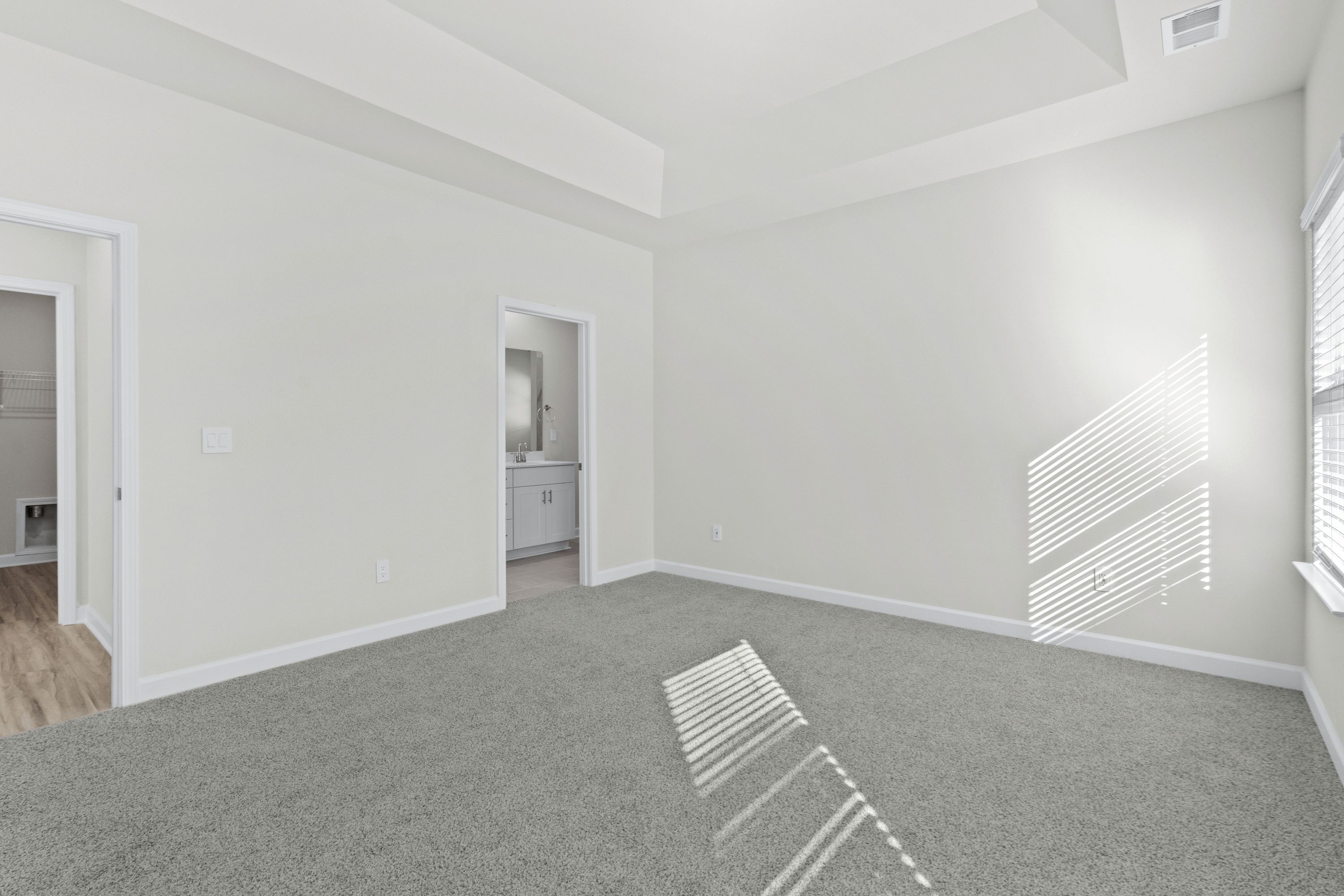 Relax and recharge in the spacious, light-filled primary suite.