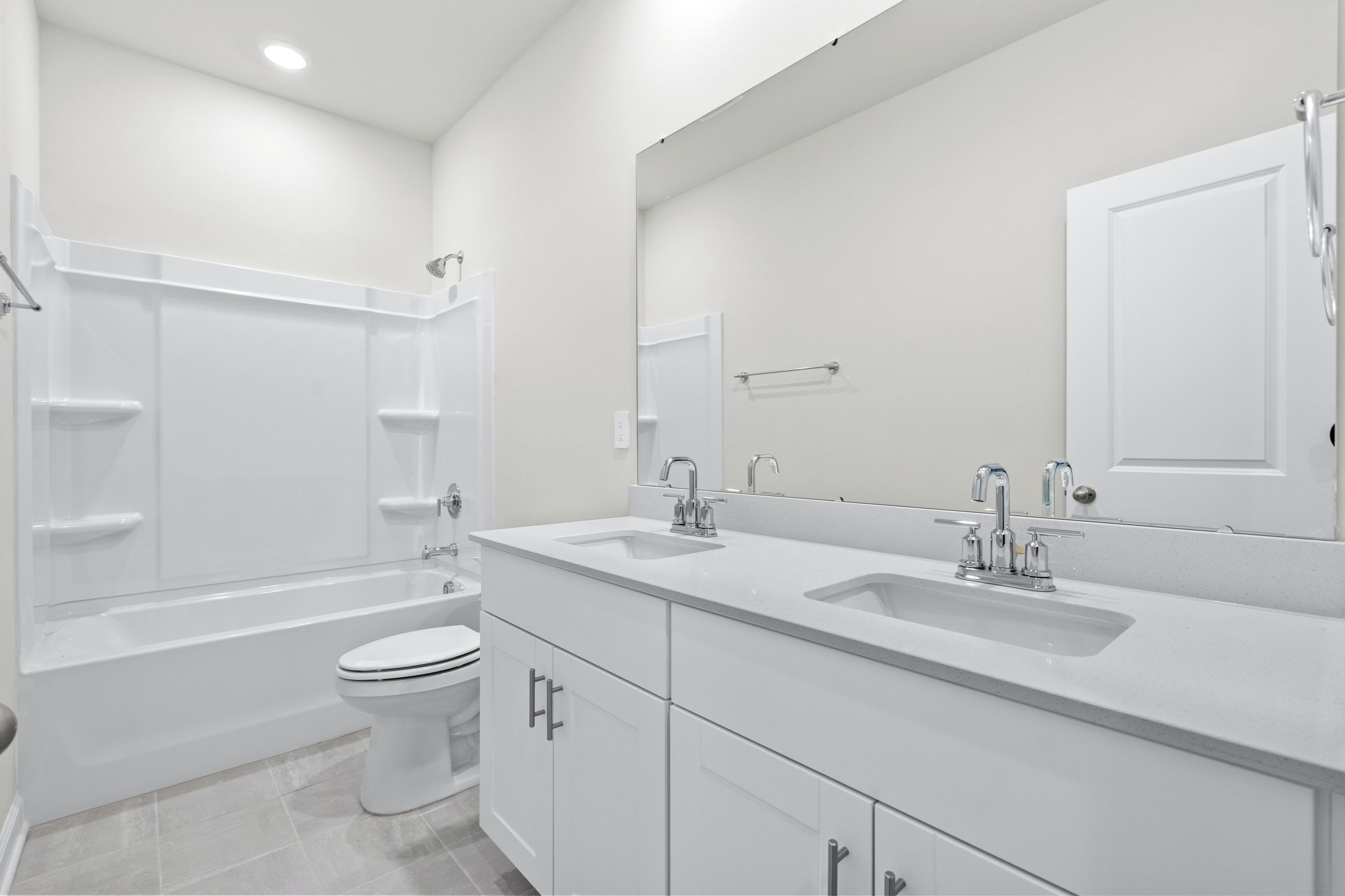 A full bathroom with duel sinks is located next to the secondary bedrooms.