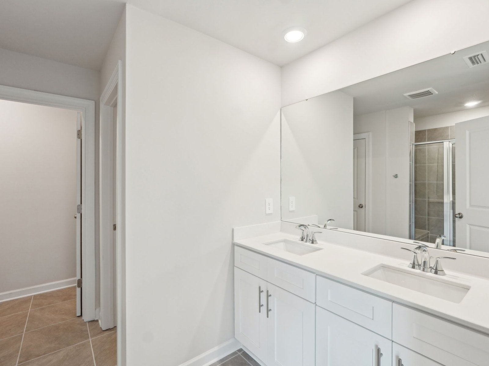 The primary bathroom boasts a dual-sink vanity and walk-in shower.