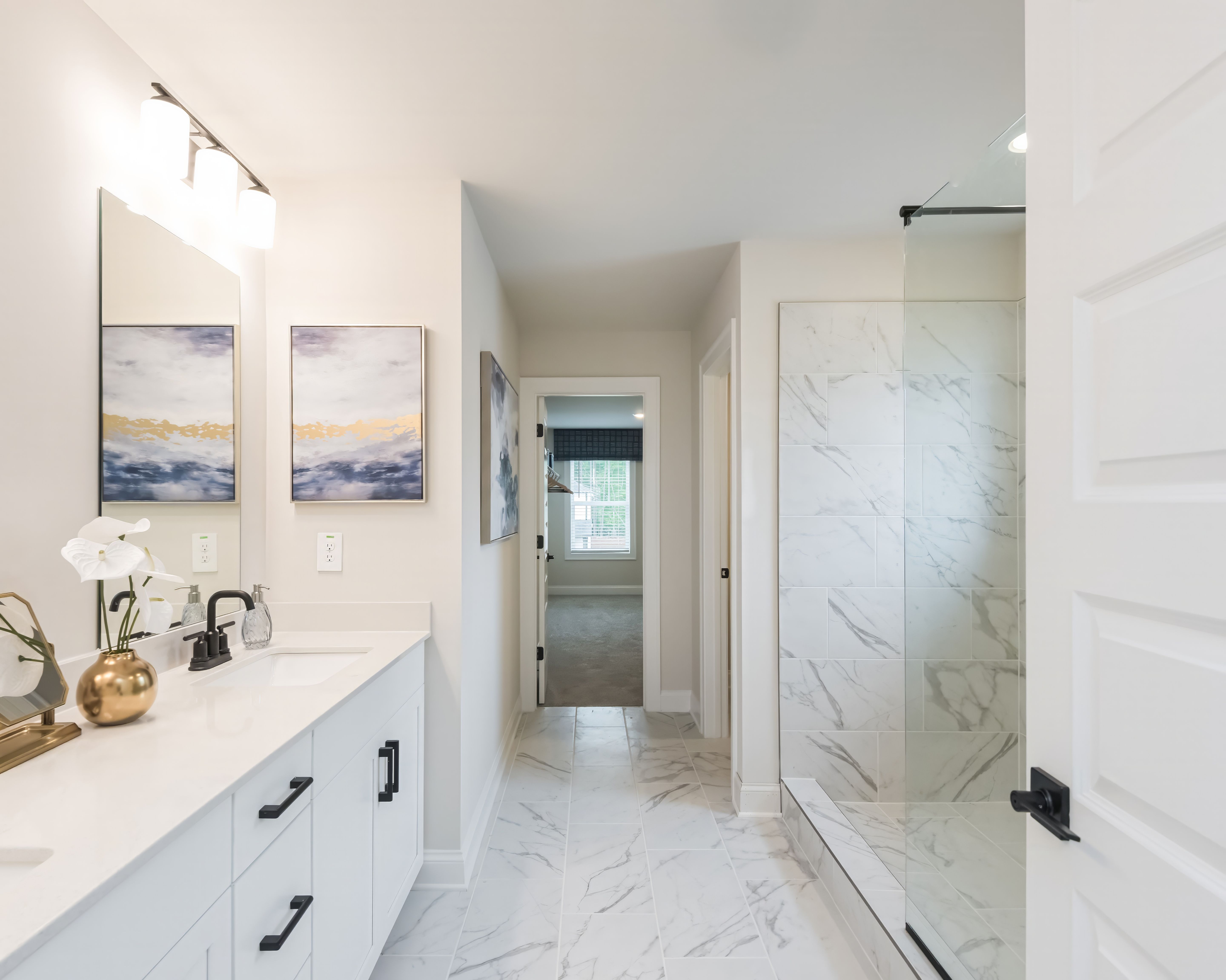 The primary suite boasts a walk-in shower and dual-vanity sinks.