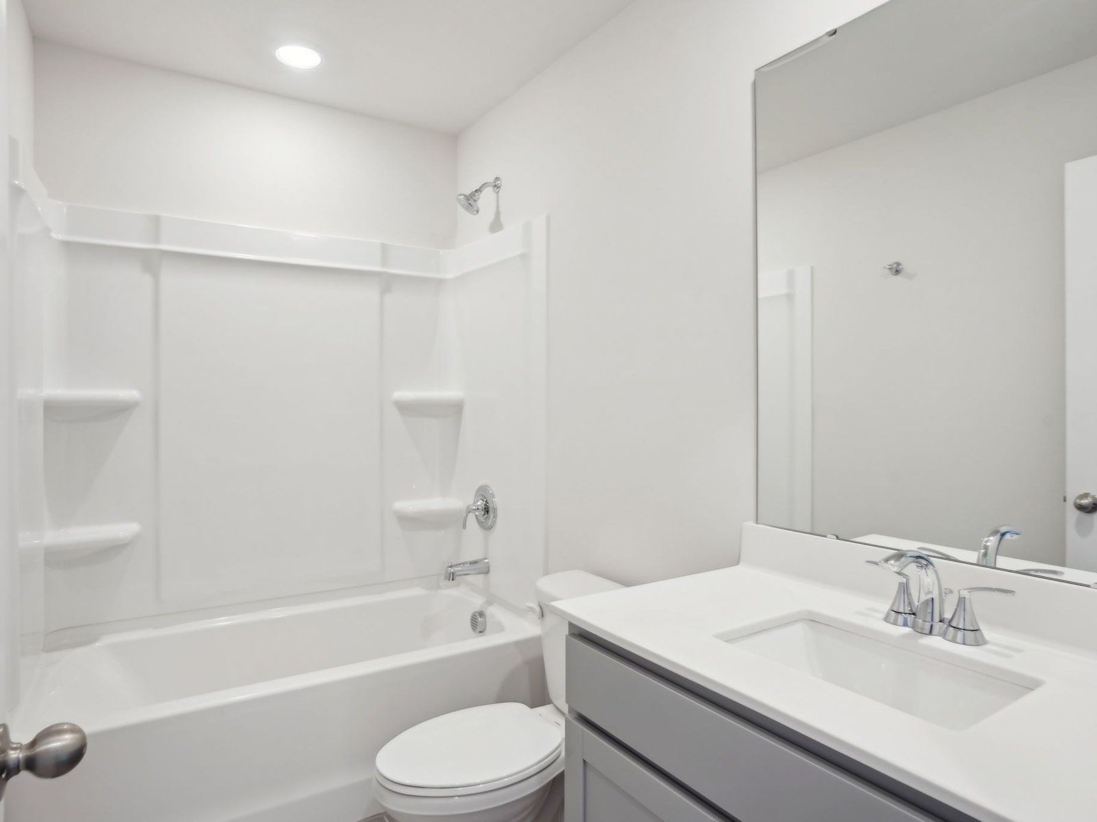 The secondary bathroom features a modern vanity and oversized shower tub.