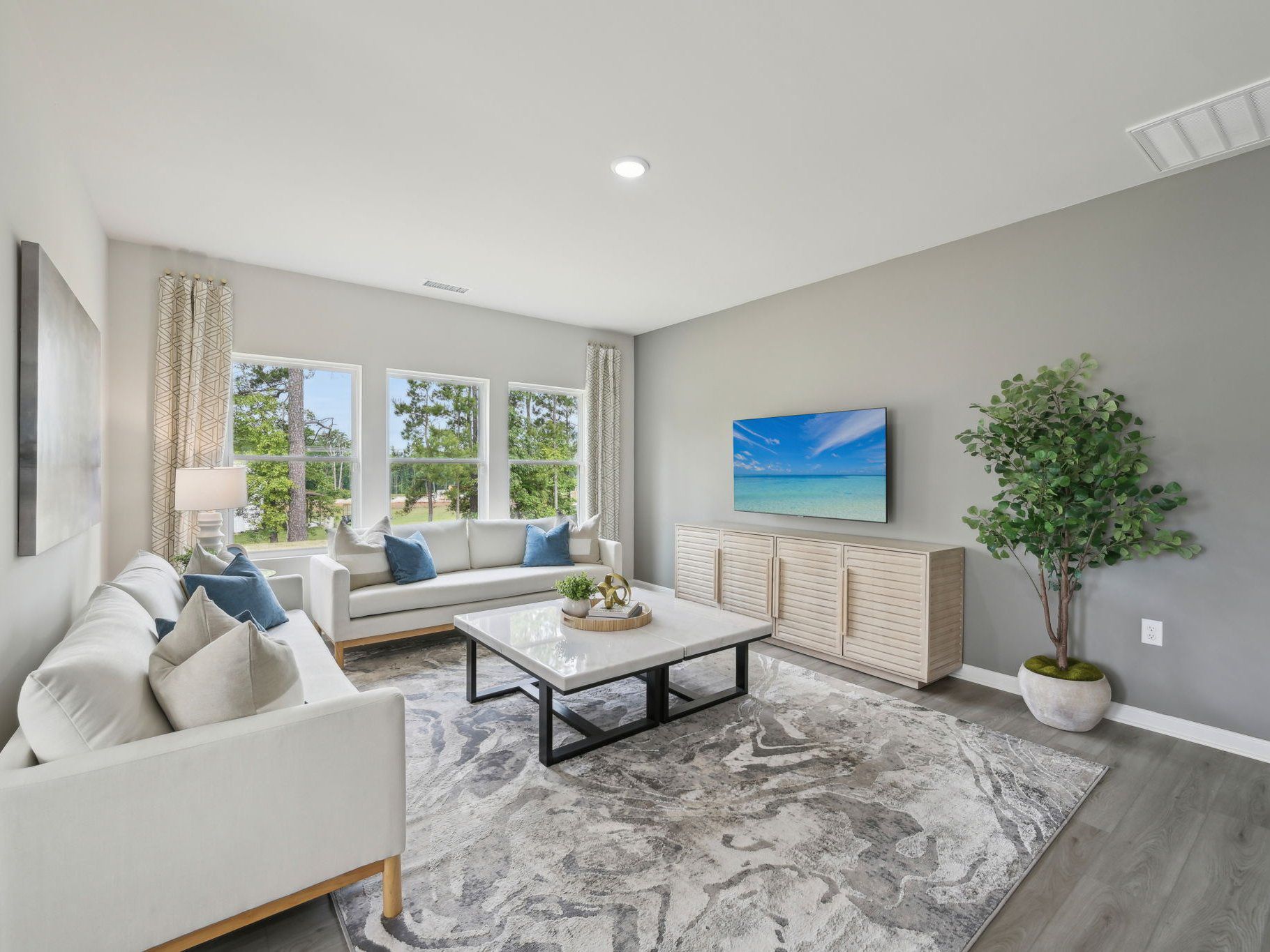An abundance of natural light floods the living, dining and kitchen areas.