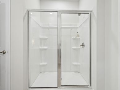 The luxurious primary suite featuring a tray ceiling, dual sinks and a spacious closet.