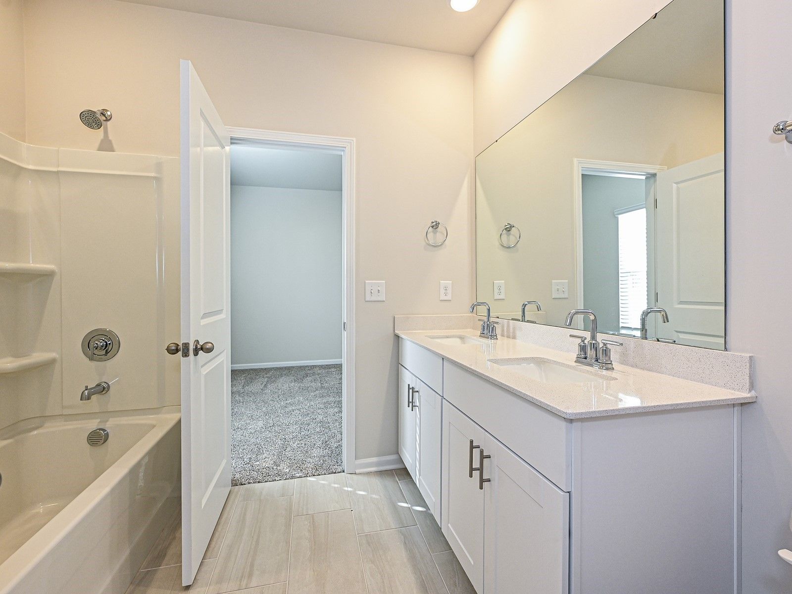 The secondary bathroom features a dual-sink vanity and oversized shower tub.