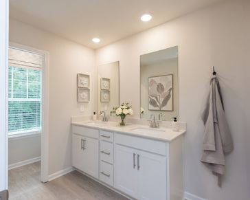 The primary bathroom features dual-vanity sinks and plenty of counter space for convenience.