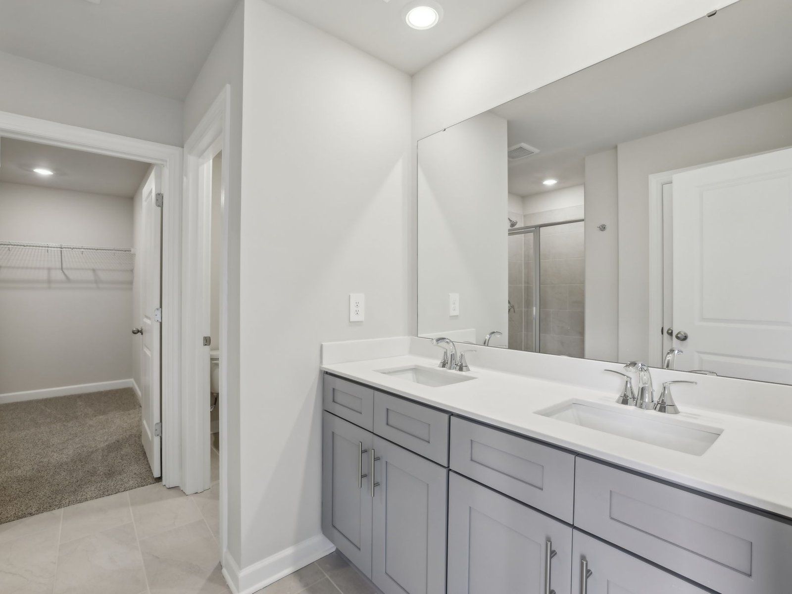 The primary bathroom boasts a dual-sink vanity and modern walk-in shower.