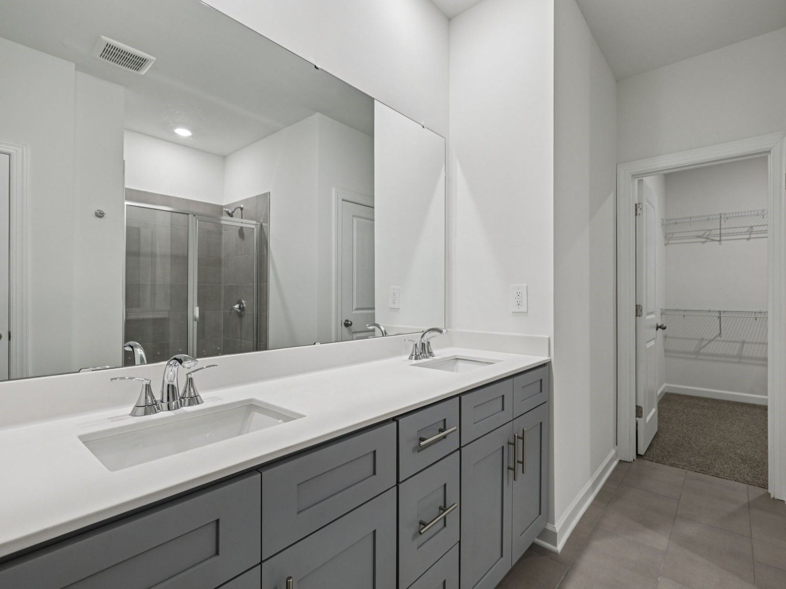 The primary bathroom boasts a dual-sink vanity and walk-in shower.