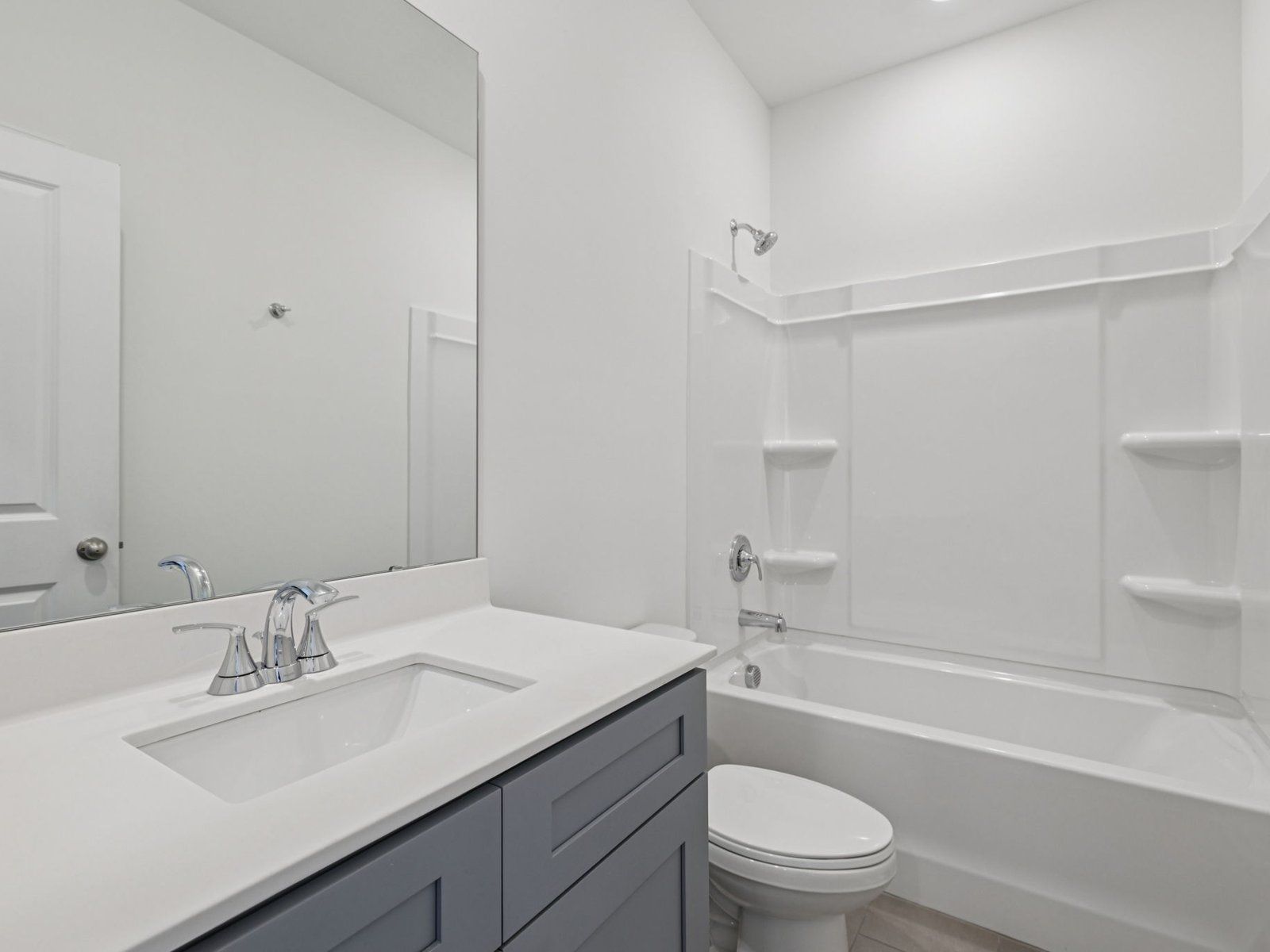 The secondary bathroom features a large vanity and oversized shower tub.