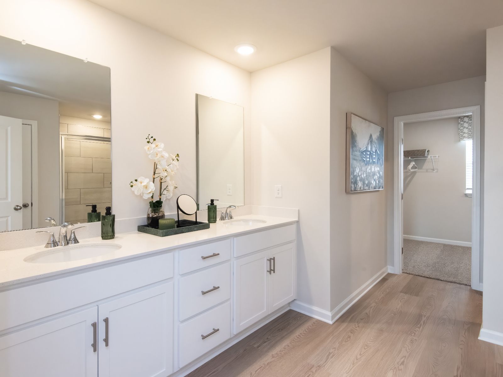 The primary bathroom boasts a dual-sink vanity and modern walk-in shower.
