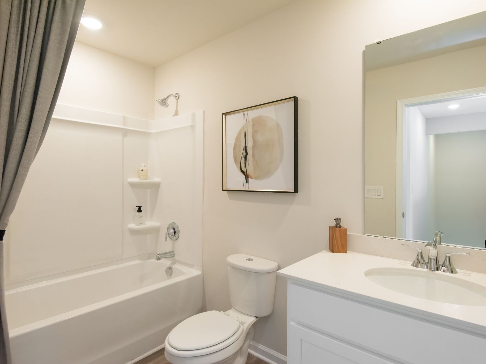 The secondary bathroom includes a spacious vanity and oversized shower tub.