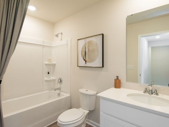The secondary bathroom includes a spacious vanity and oversized shower tub.