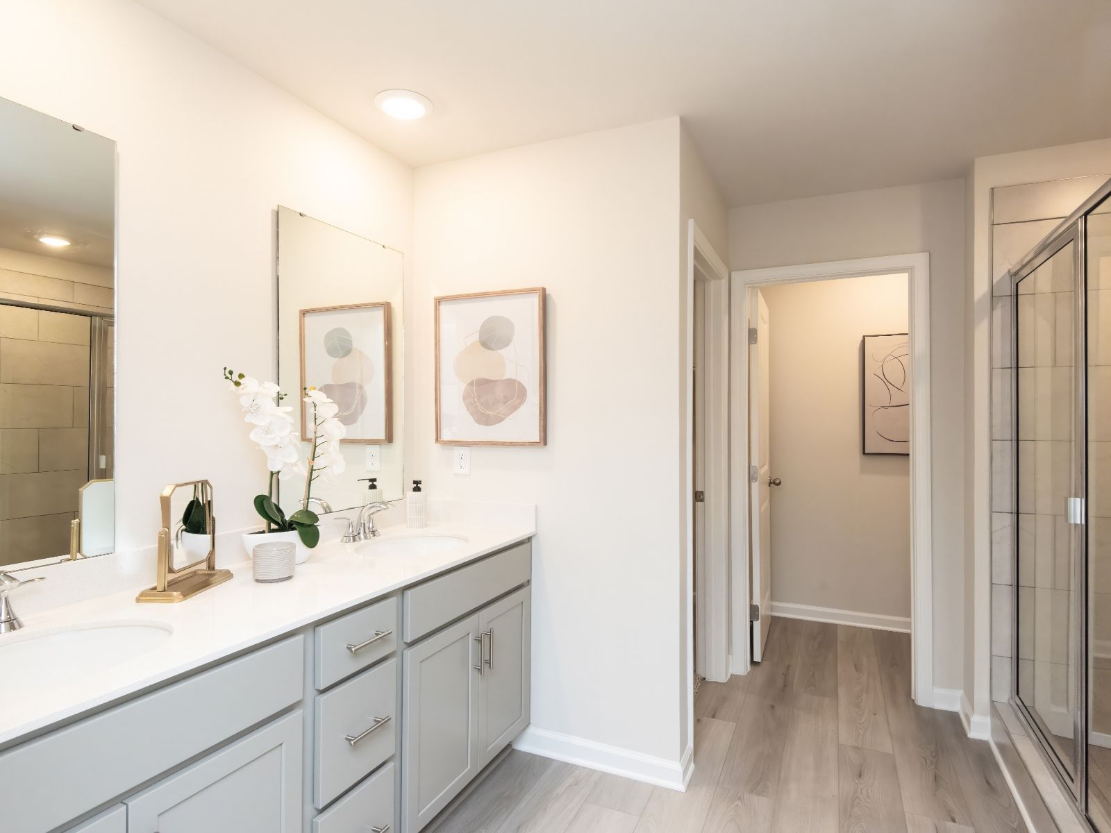 The primary bathroom boasts a dual-sink vanity and spacious walk-in shower.