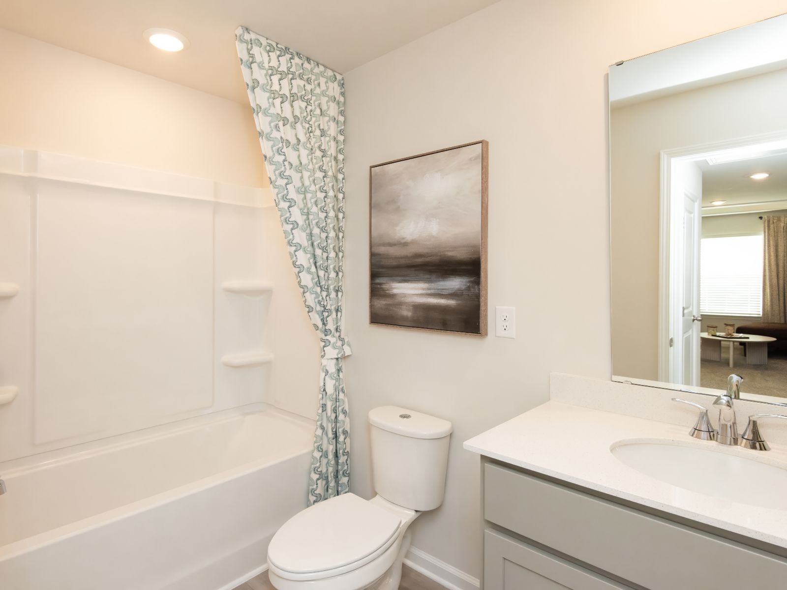 The secondary bedroom features a modern vanity and oversized shower tub.