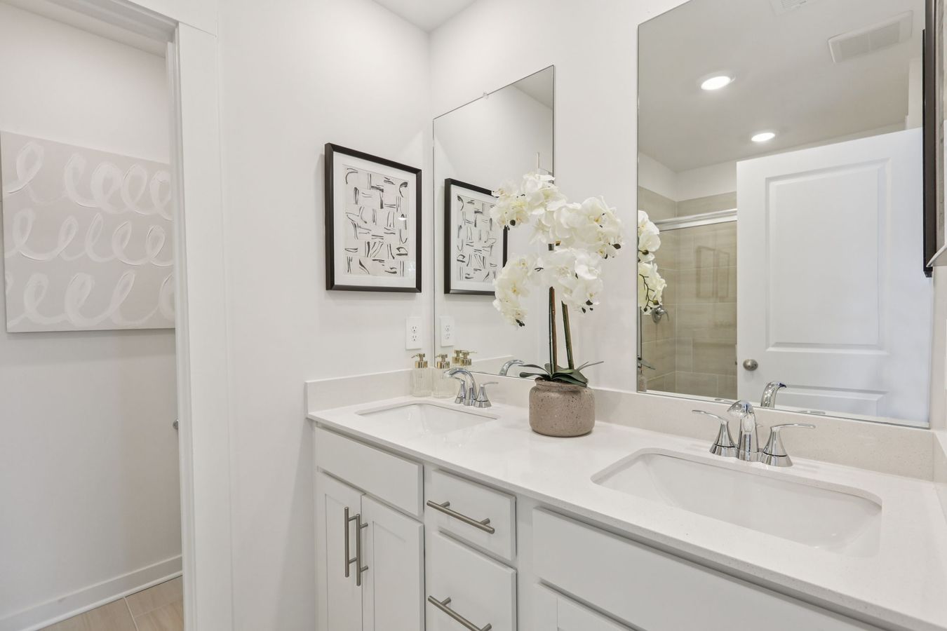 The primary bathroom offers dual vanity sinks and a walk-in shower.