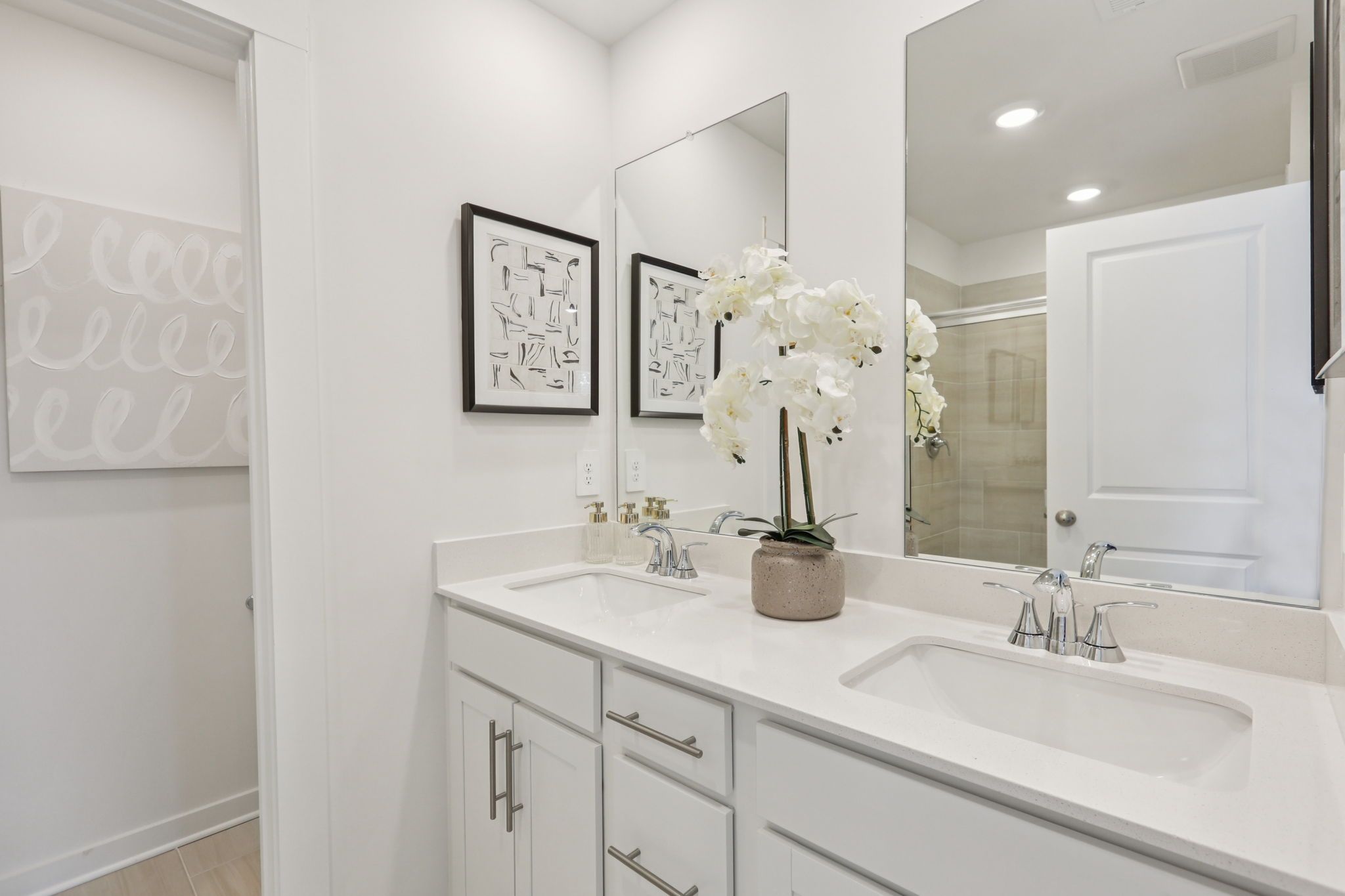 The primary bathroom offers dual vanity sinks and a walk-in shower.