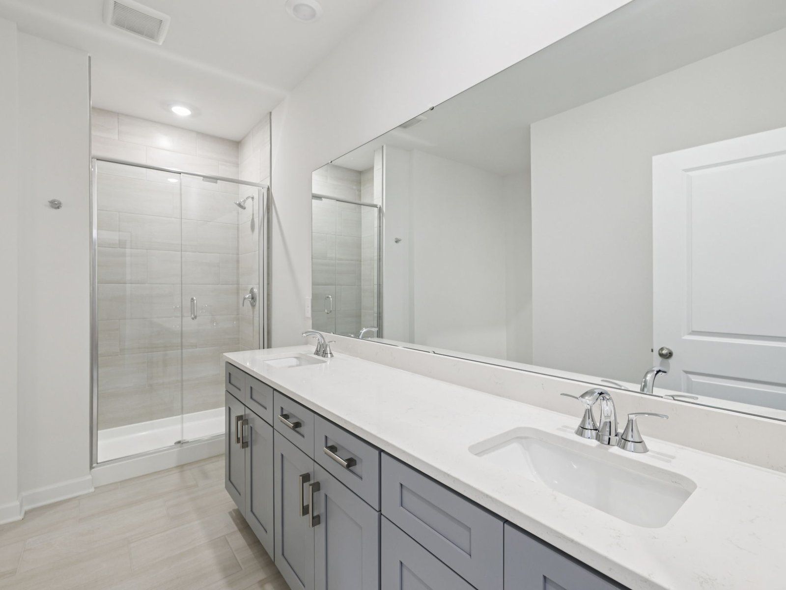 The primary bathroom boasts a large dual-sink vanity and modern walk-in shower.