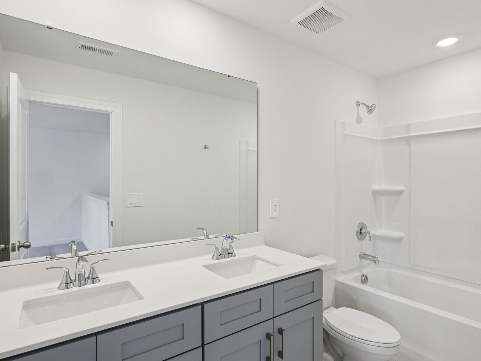 The secondary bathroom features a dual-sink vanity and oversized shower tub.
