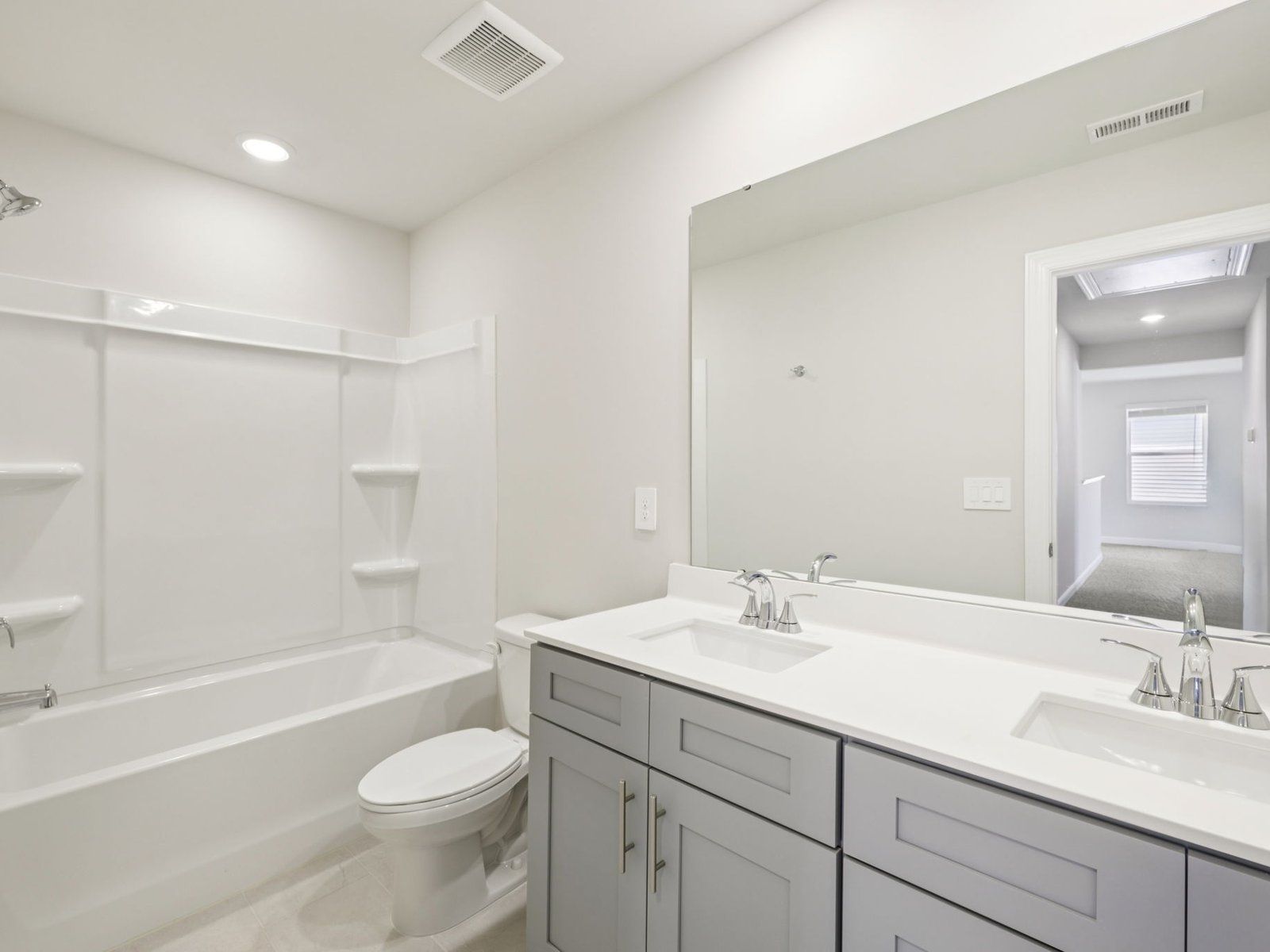 The secondary bathroom features a modern vanity and oversized shower tub.
