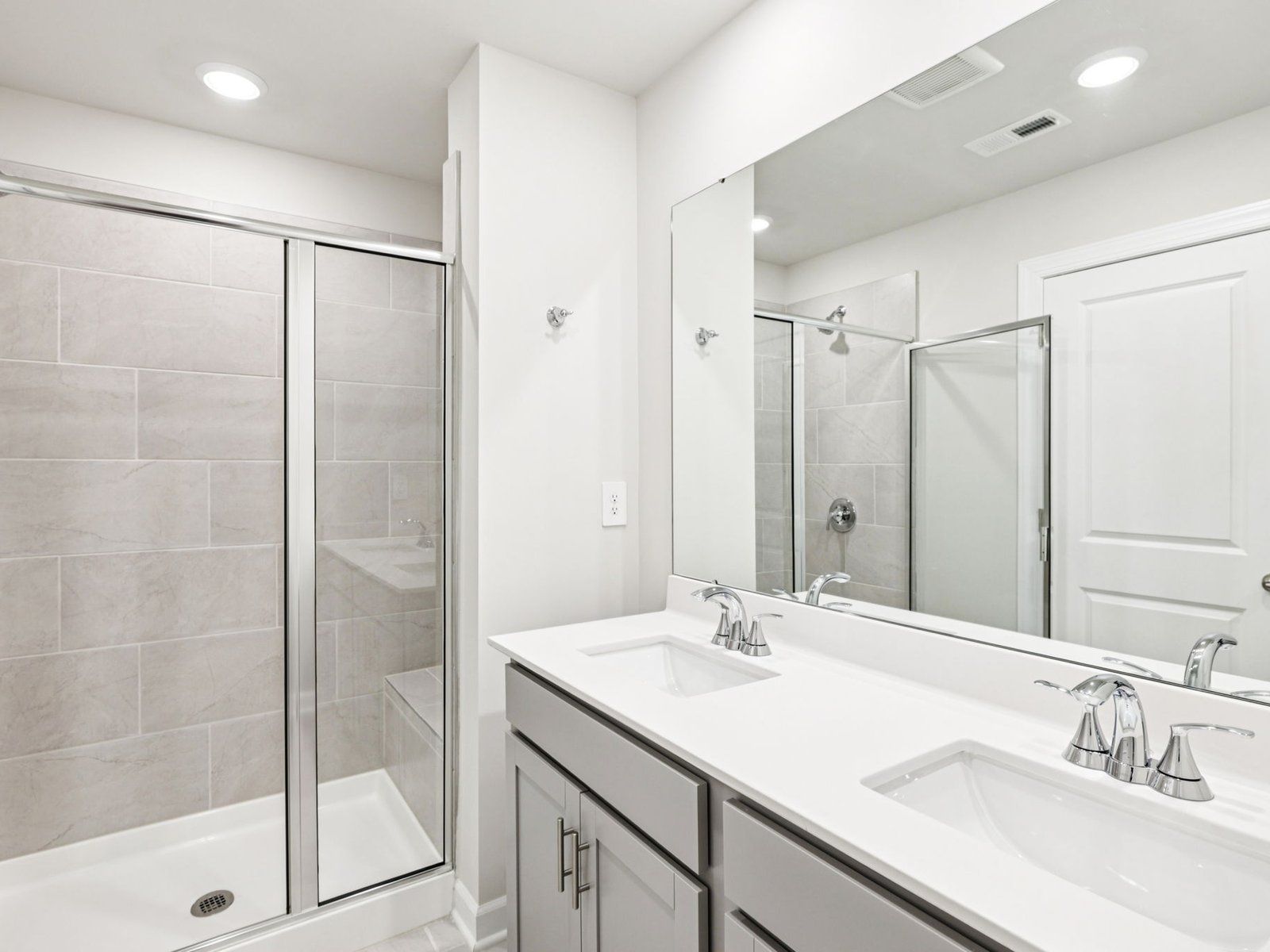 The primary bathroom boasts a dual-sink vanity and modern walk-in shower.
