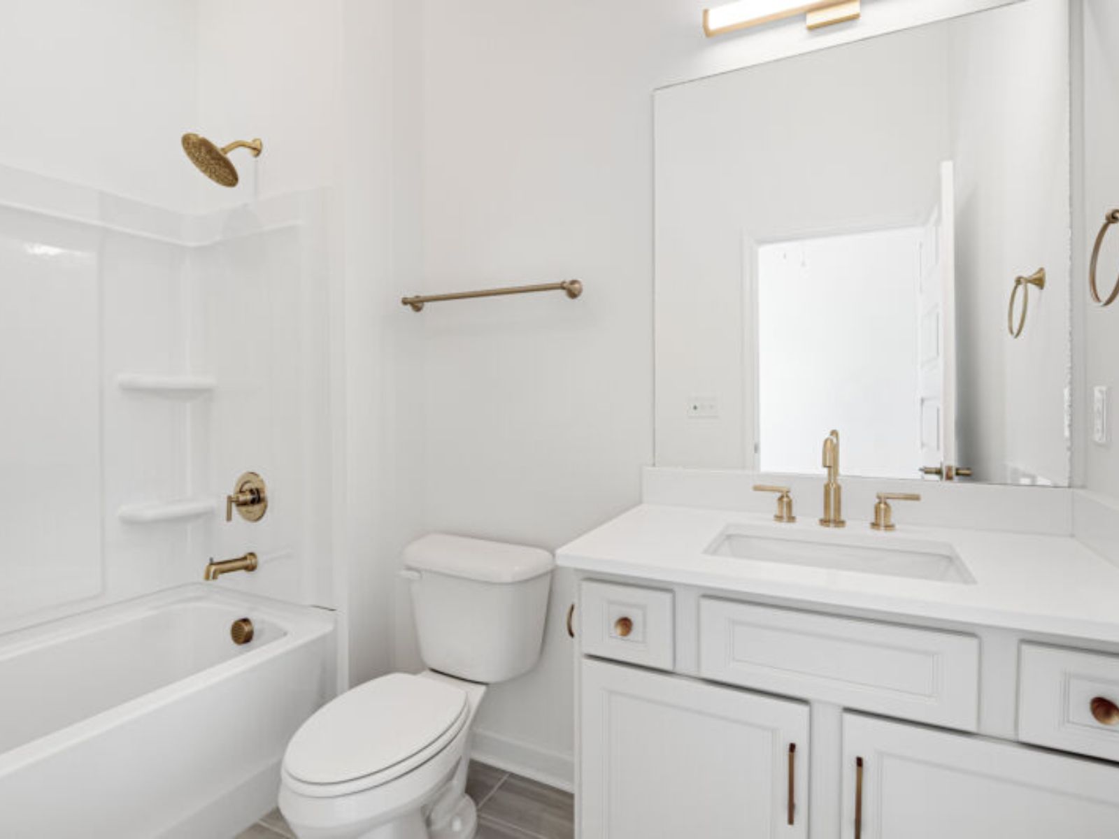 The secondary bathroom offers a functional bathtub, toilet, and sink.