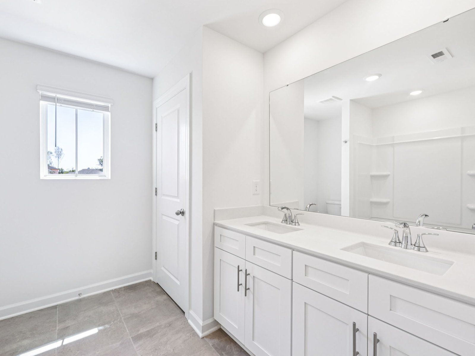 The secondary bathroom features a dual-sink vanity and oversized shower tub.