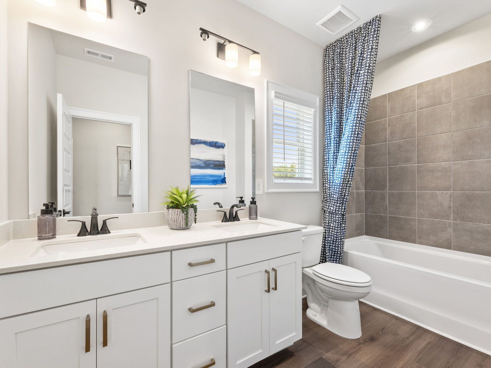 The upstairs secondary bathroom features a dual-sink vanity and oversized shower tub.