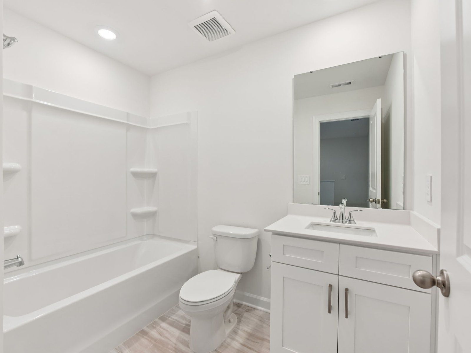 The secondary bathroom features a storage vanity and oversized shower tub.