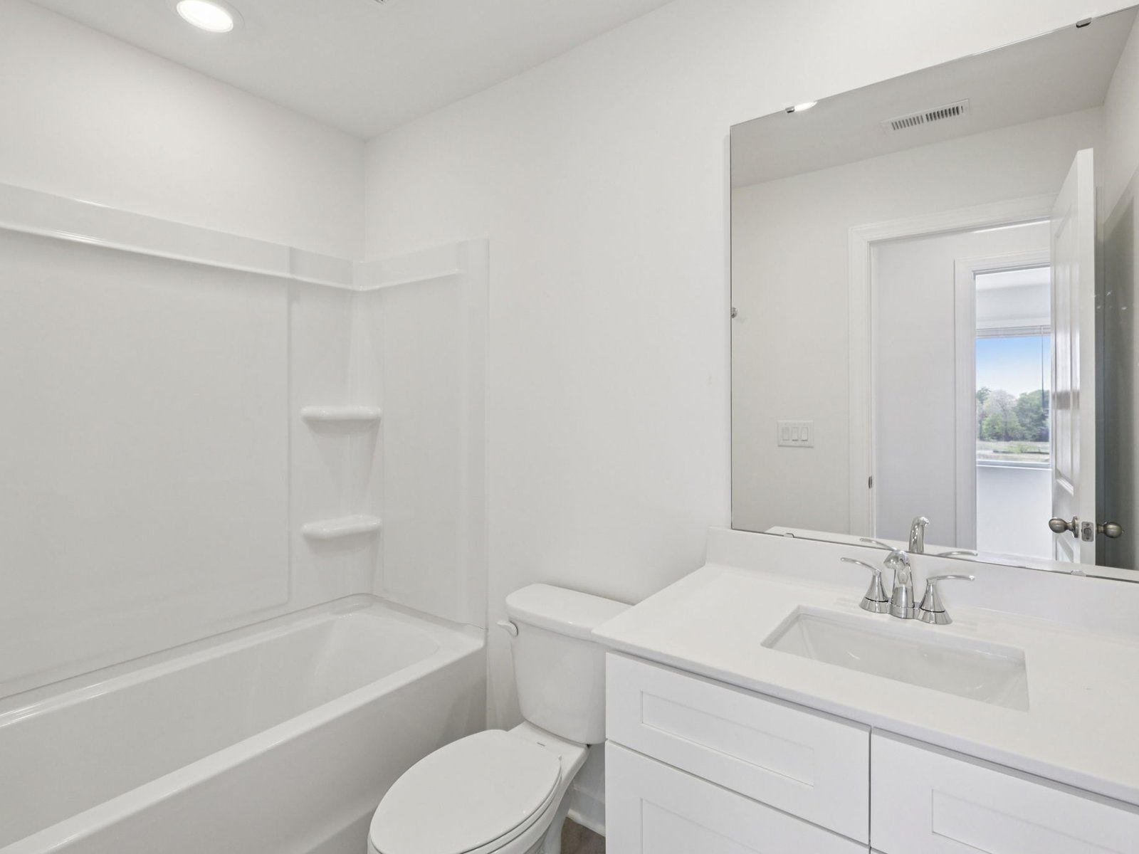 The secondary bathroom features a storage vanity and oversized shower tub.