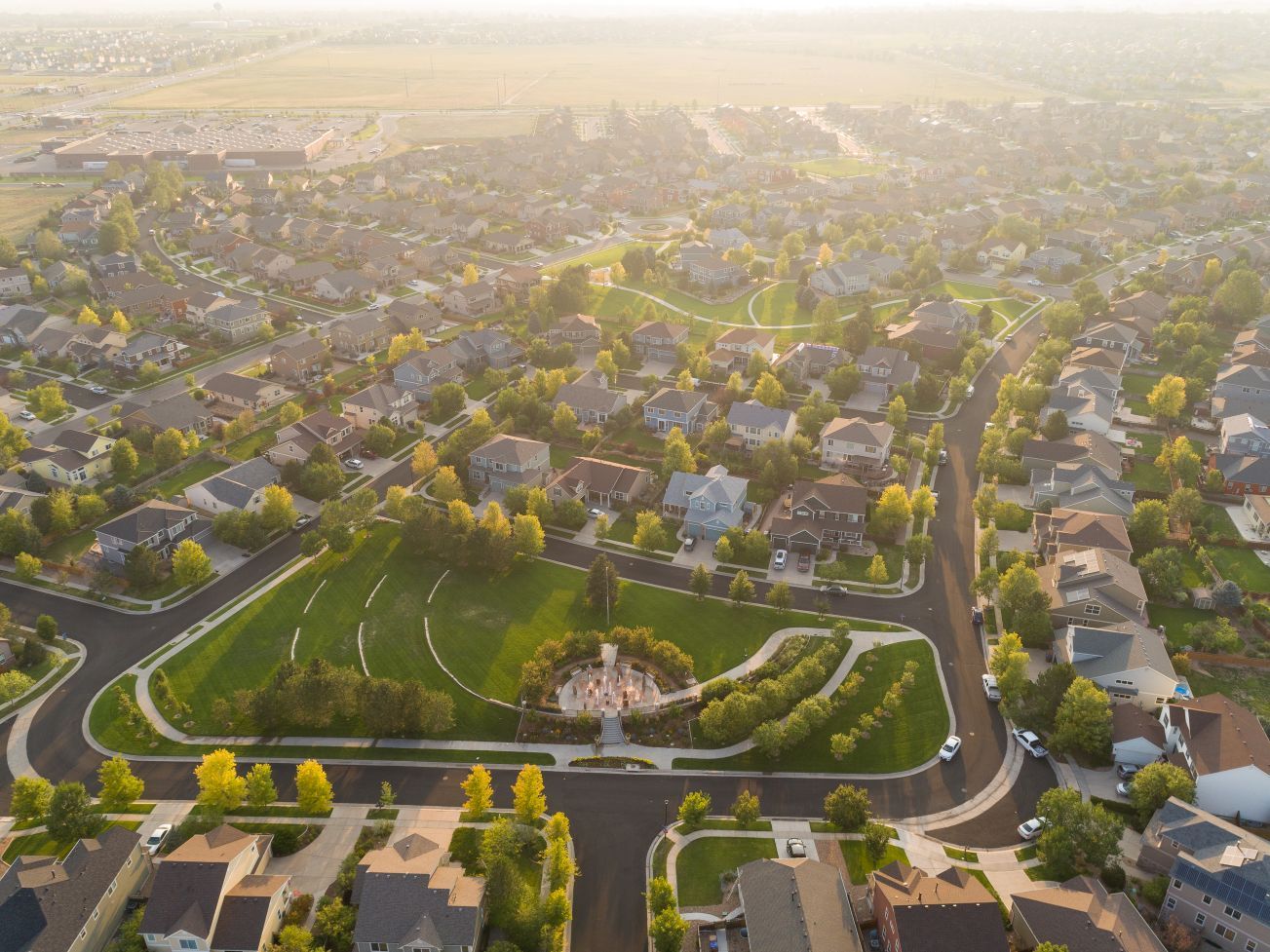 Dusk aerial view of the neighborhood, with warm lights glowing as the day winds down.