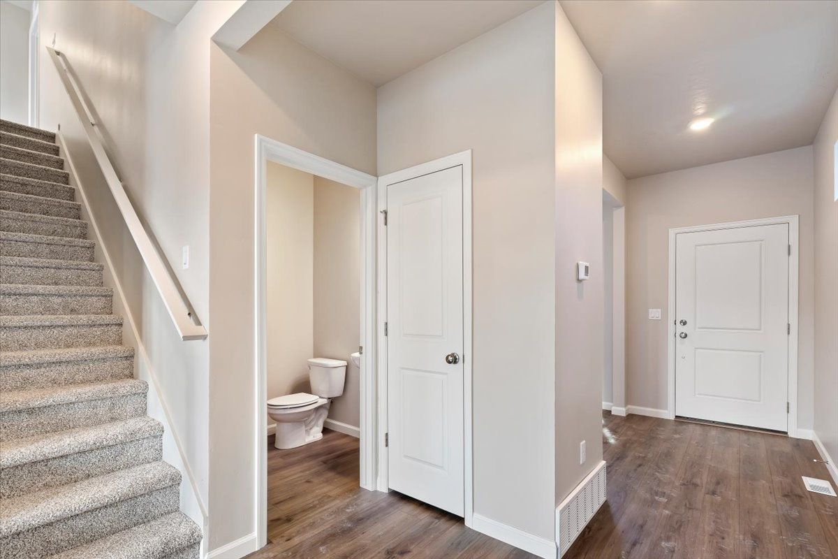 A view of the stairwell, entry and powder room