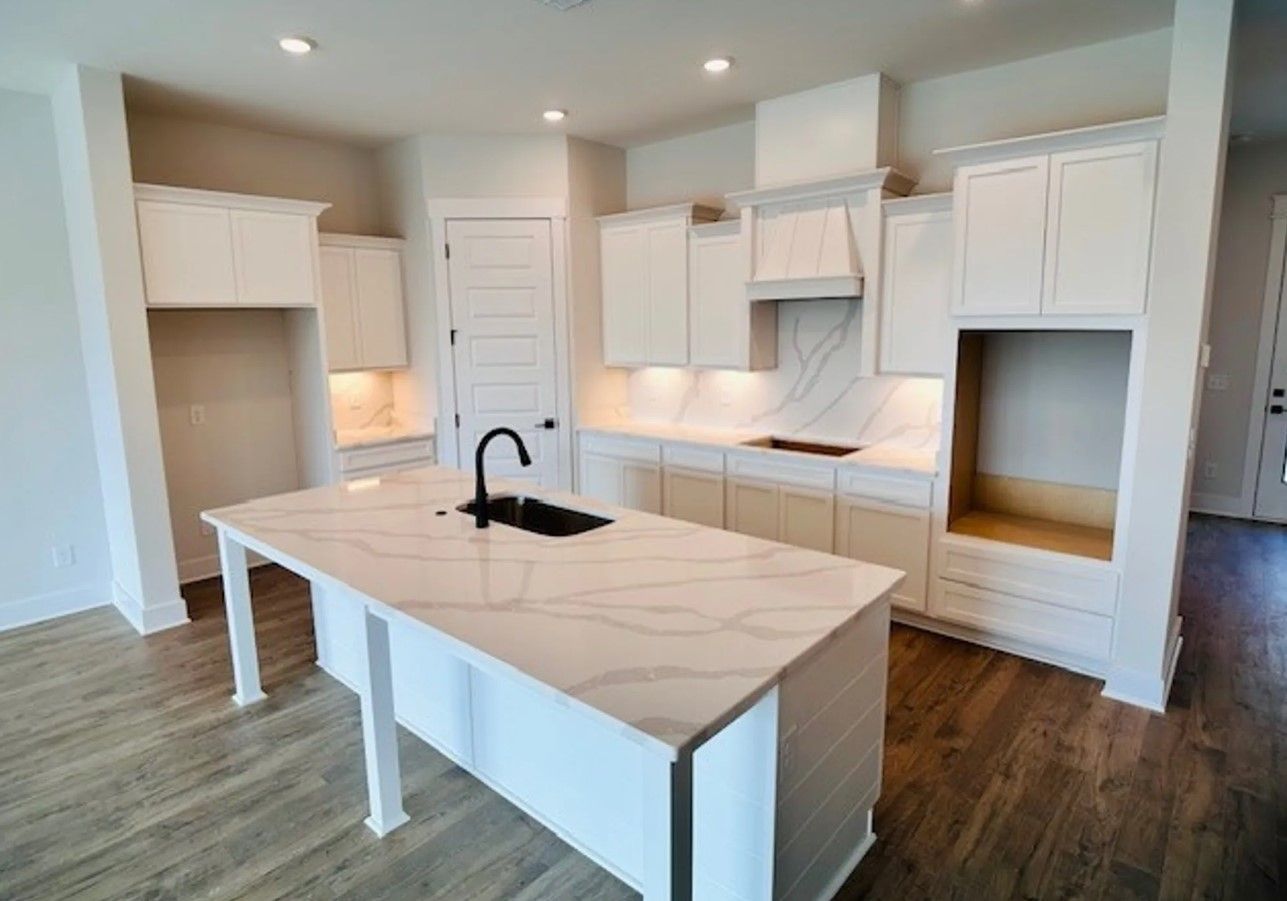 Great kitchen layouts that hosts a pantry, staggered cabinets, and quartz countertops