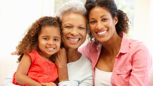 Mother,daughter and granddaughter at home smiling at the camera