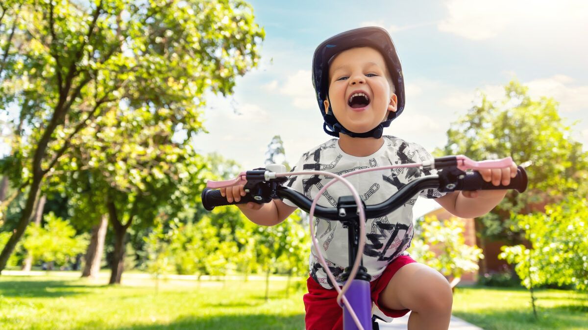 Toddler ridding a bike smiling