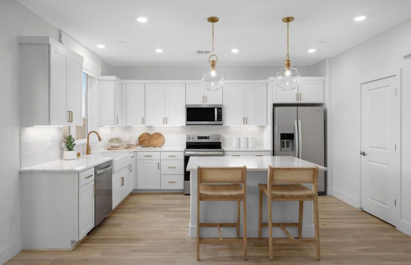 Kitchen with white shaker cabinetry and gold hardware