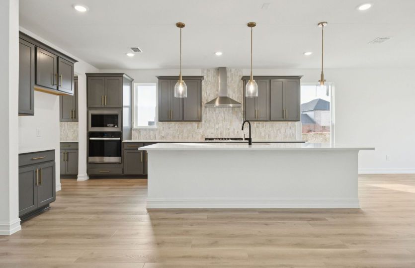 Spacious kitchen with recessed and pendant lighting *photos may depict options and features that are
