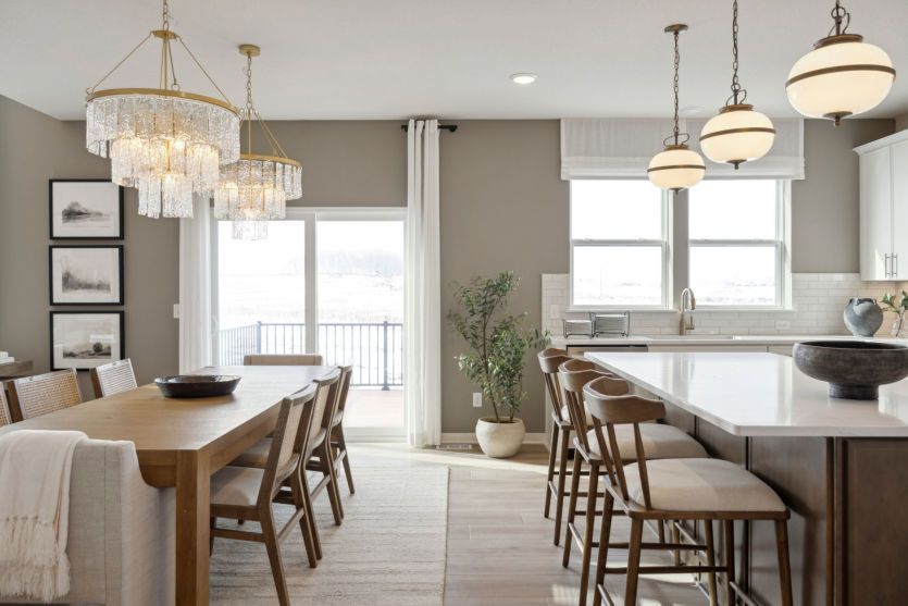 Spacious dining room with a formal table setting, large windows, and warm accents.