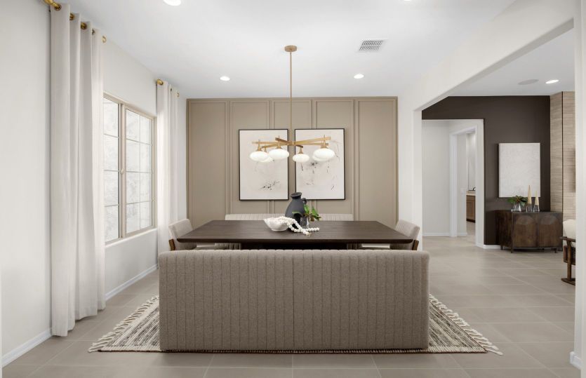 The formal dining space in the Ravenna decorated with trim detail and a decorative light fixture.