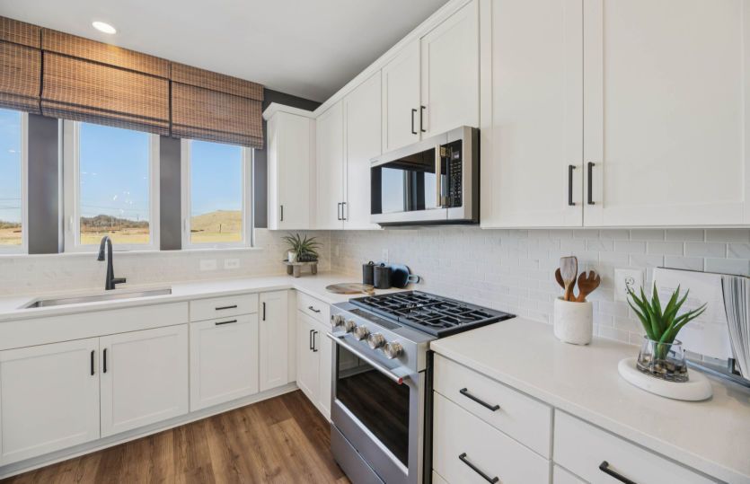 Kitchen Features Quartz Countertops and Tile Backsplash