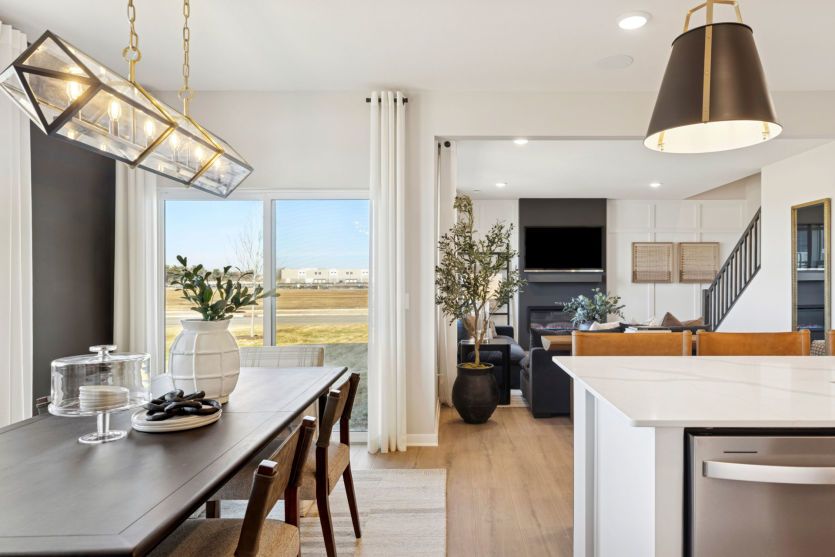 Standing between the dining room and kitchen, gazing into the gathering room beyond