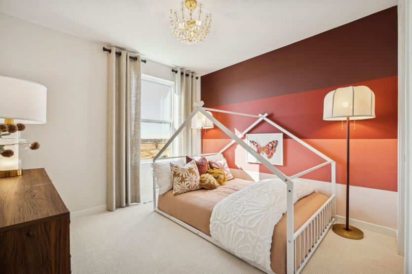Comfortable secondary bedroom with warm decor and plenty of natural light.