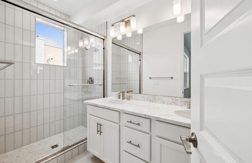 Primary bathroom with dual vanity and a glass walk-in shower