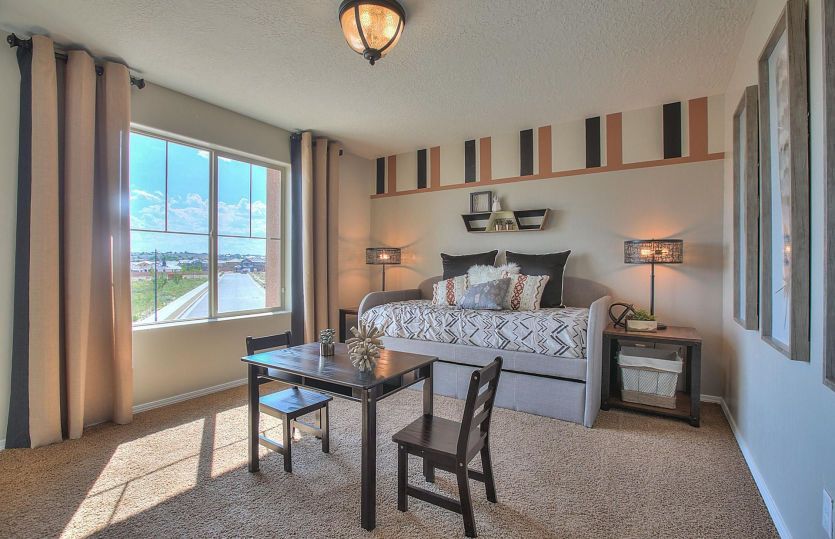 One of the secondary bedrooms upstairs showcasing a big, bright window and custom paint accents.