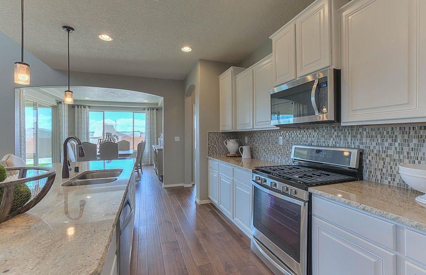 Messina kitchen shown with white cabinets, granite countertops, and stainless steel appliances.