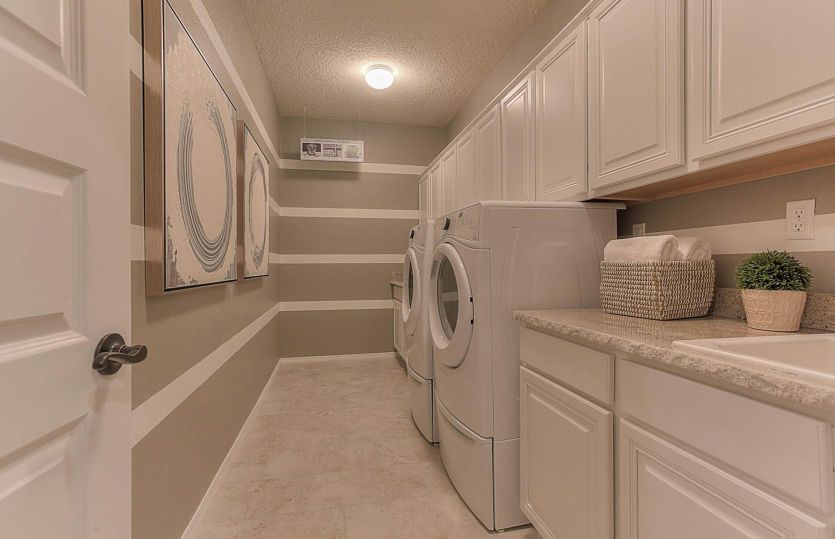 Large laundry room complete with extra cabinets for plenty of storage space.