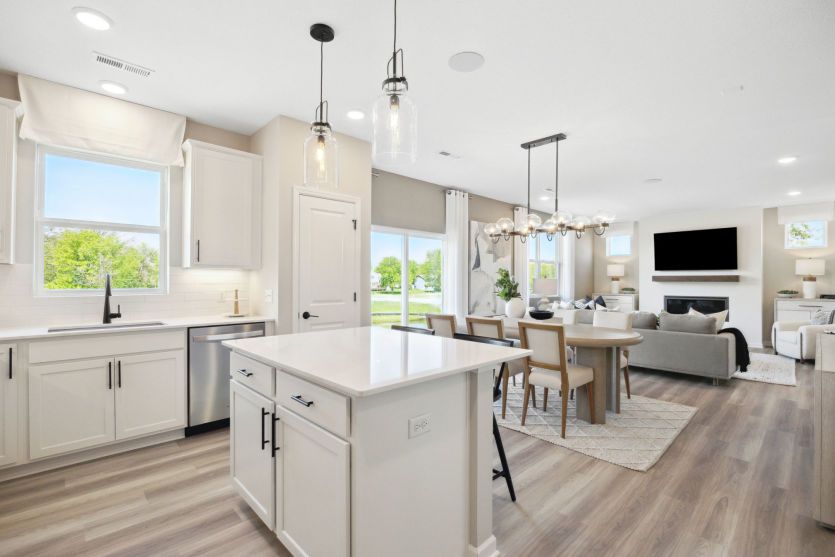 Standing in the kitchen, looking into the dining and gathering rooms beyond